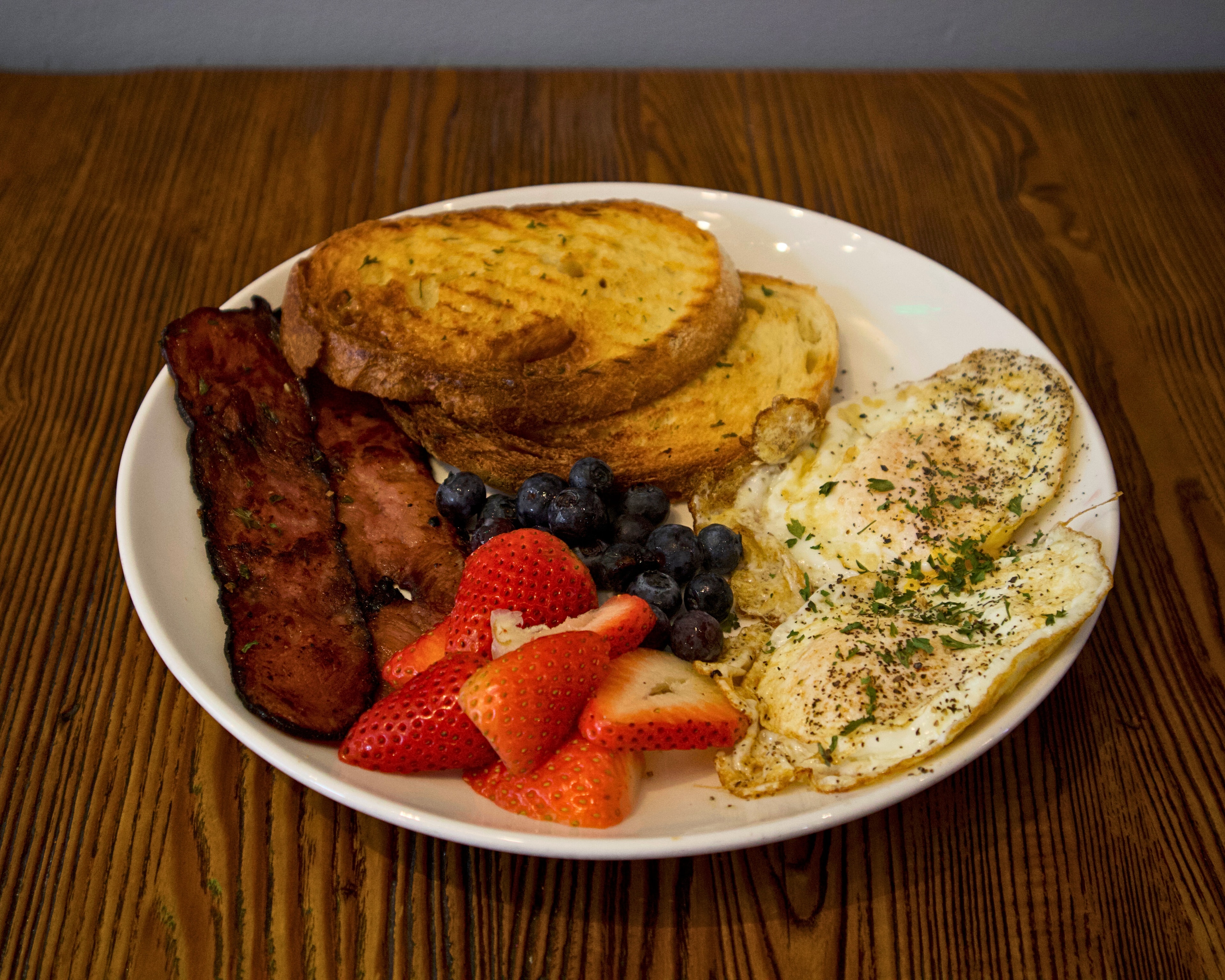 Breakfast platter with eggs, bacon, toast and fresh berries